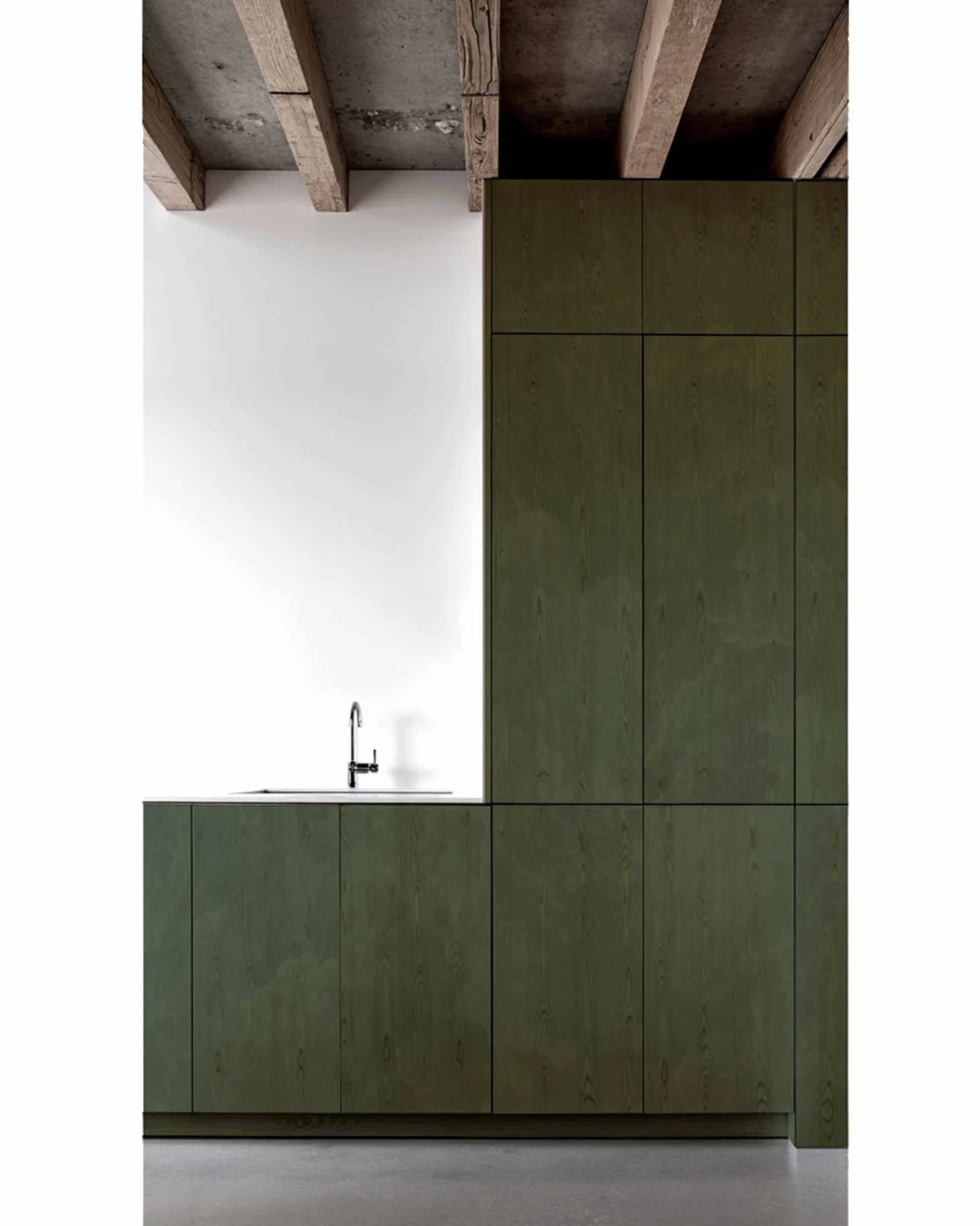 Cuisine rurale moderne et contemporaine avec façades en bois vert et plafond brut à poutres apparentes, conception architecturale signée Arthur Montessuit, Architecte en Haute-Savoie.