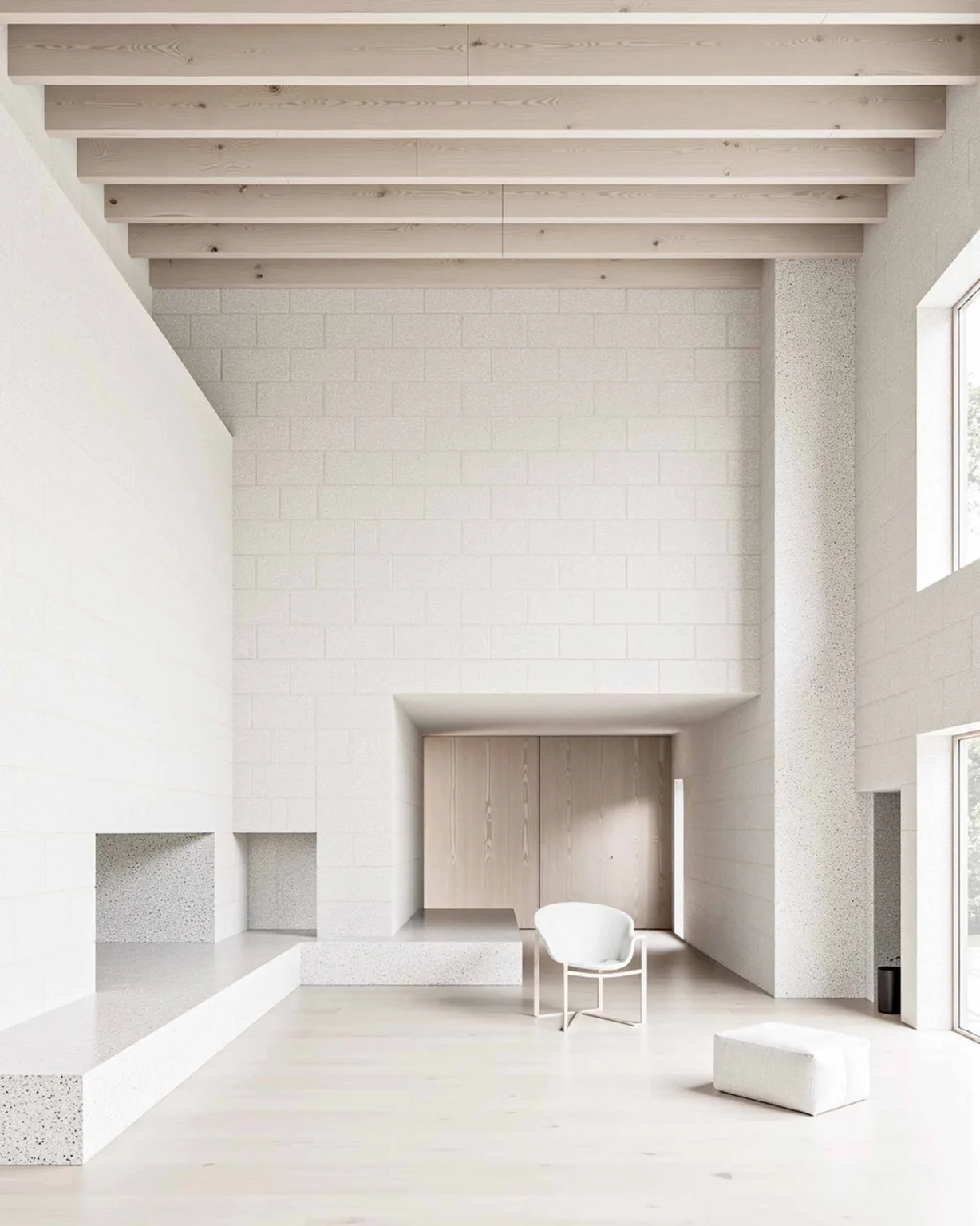 Espace rural moderne et contemporain aux murs en blocs de pierre clairs et assises en terrazzo, conception architecturale par Arthur Montessuit, Architecte en Haute-Savoie.